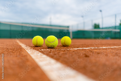 small bright balls lie on clay tennis court professional sport training hobby playing outside © Guys Who Shoot