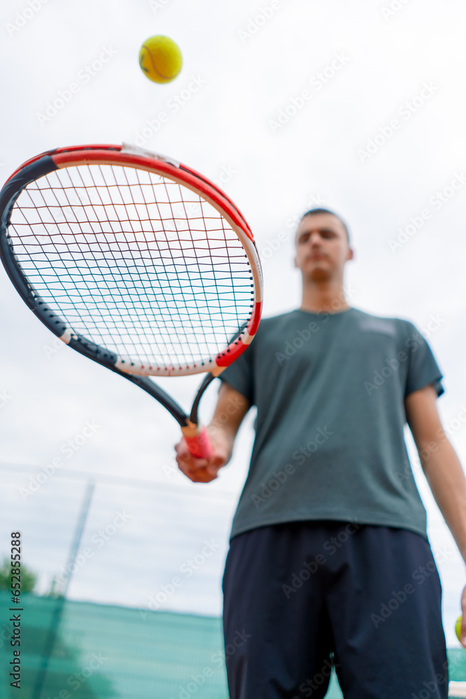 close-up young tennis player trainer hitting the ball with a racket on the tennis court preparing for the competition sports lifestyle