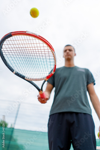 close-up young tennis player trainer hitting the ball with a racket on the tennis court preparing for the competition sports lifestyle © Guys Who Shoot