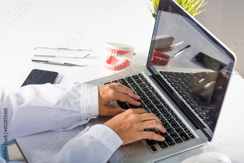 Foto Dentist doctor or nurse in uniform use oral software teeth Xray and typing infor