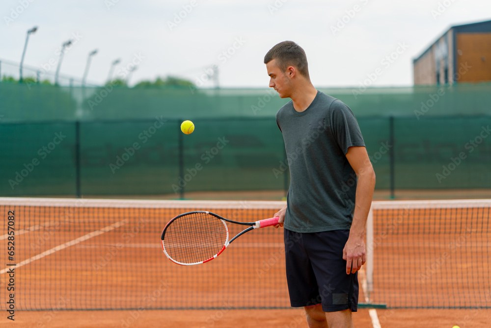 young tennis player coach hitting the ball with a racket on the tennis court preparing for the competition sports lifestyle