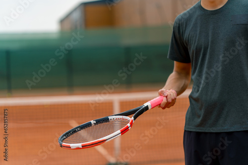 close-up young tennis player trainer hitting the ball with a racket on the tennis court preparing for the competition sports lifestyle © Guys Who Shoot