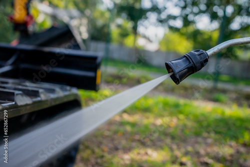 Fotografie High pressure water stream washer nozzle cleaning heavy construction equipment