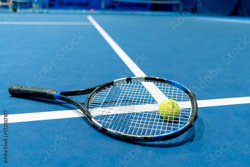close-up sports equipment tennis ball and racket lie on indoor professional blue court hobby competition sport