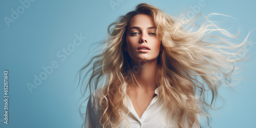 Portrait of Beautiful Woman with Long Wavy Hair isolated on pastel blue background. Hair Flying in the Wind, copy space