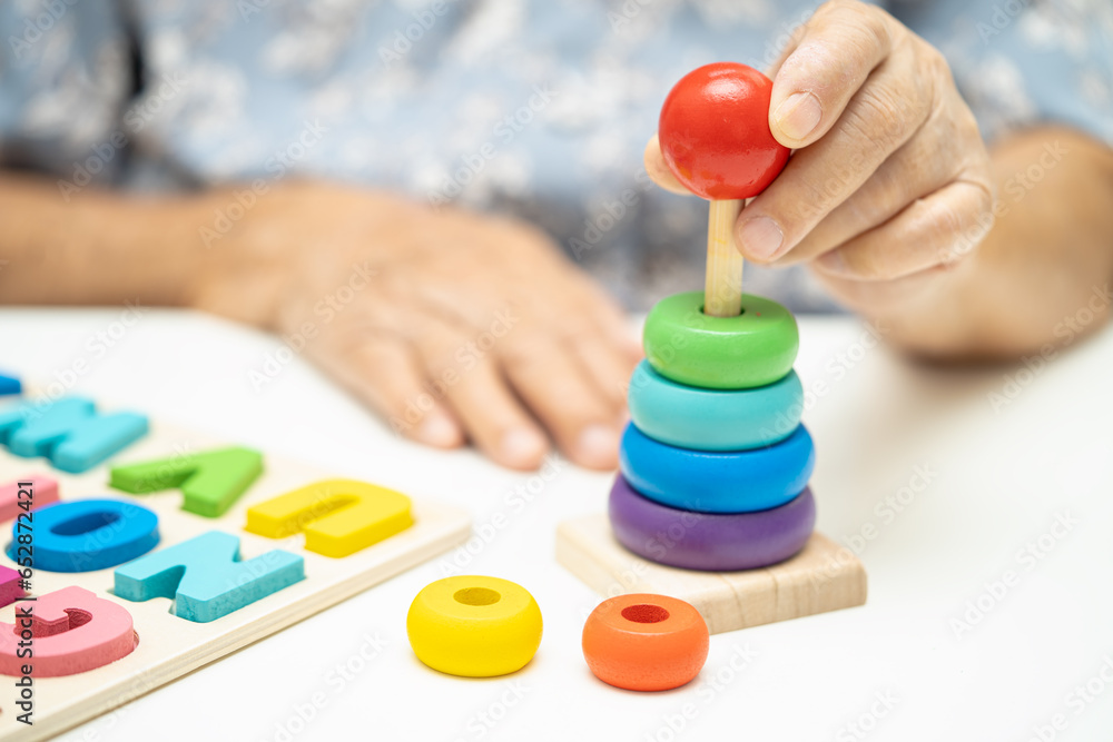 Alzheimer disease AD, Asian elderly woman patient suffering from dementia learn practical motor skills rehabilitation. Alzheimer disease AD, Asian elderly woman patient suffering from dementia learn practical motor skills rehabilitation.