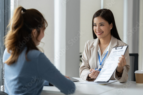 Businesswoman, office worker working using laptop and mobile phone in real estate accounting analysis reporting, discussing agreement contract documents financial and tax system concepts.