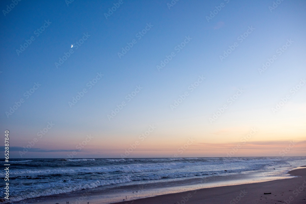 the moon on a clear beautiful early evening on an empty Amagansett, NY beach the moon on a clear beautiful early evening on an empty Amagansett, NY beach