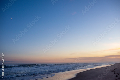 The moon and the fading day over the ocean in the hamptons, ny photo