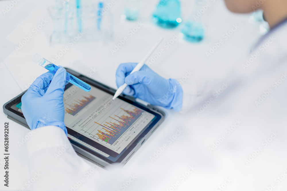 hand of scientist holding sample in test tube comparing.result chart on ...