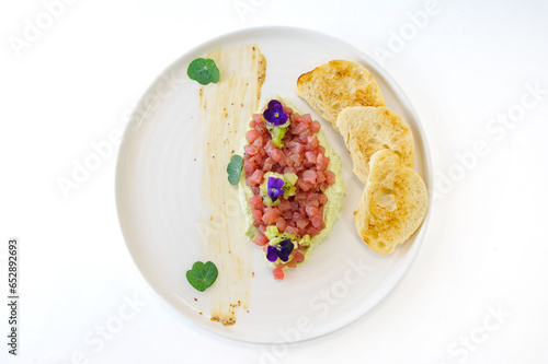 Tuna tartare with mint kiwi avocado cream and ciabatta croutons isolated