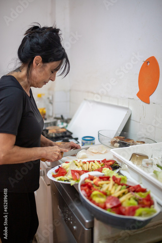 person in kitchen cooking salad