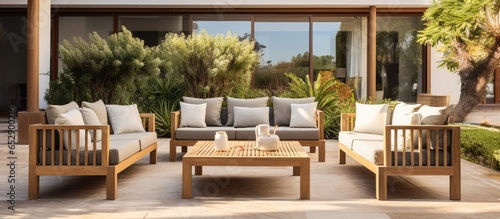 Luxurious holiday apartments or hotel with contemporary wooden furniture in an outdoor seating area on a patio © AkuAku