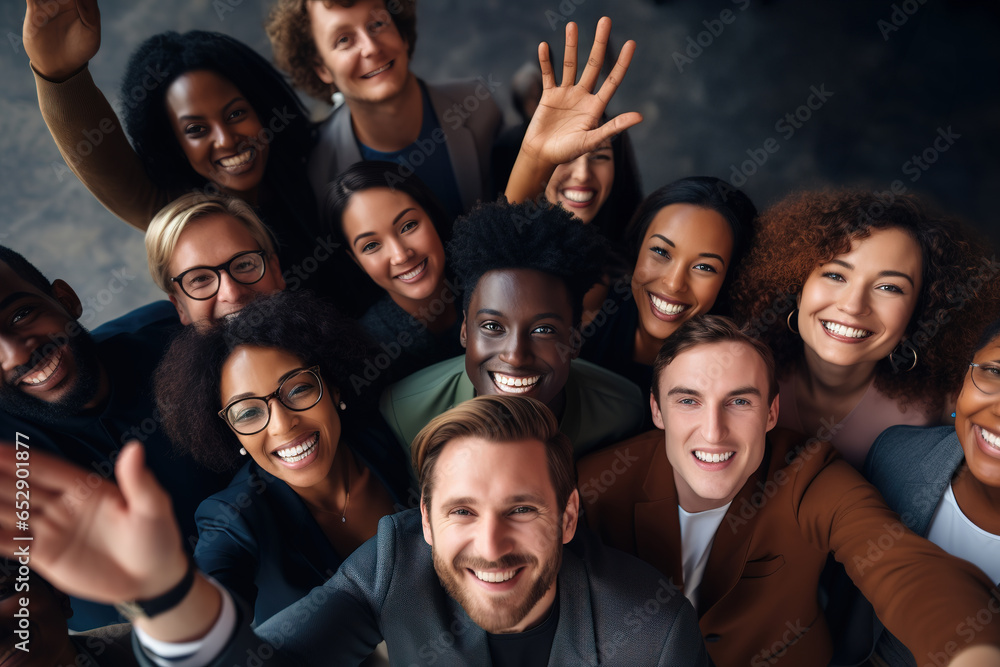 Above view of diverse group of people raising hands together, waving and smiling to camera. Above view of diverse group of people raising hands together, waving and smiling to camera.