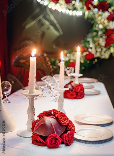 Beautiful table decorated with candles and a   red flowers. Generative AI