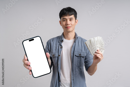 Man showing smartphone with blank white screen and holding dollar cash.