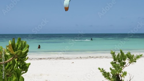 couple watching kite surfer at Jambiani beach in Zanzibar  
