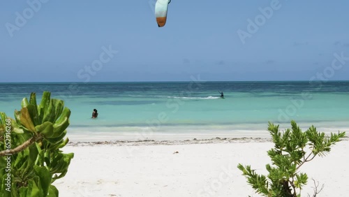 couple watching kite surfer at Jambiani beach in Zanzibar   photo