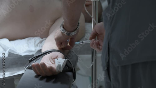 Doctor hands in gloves with syringe. Stock footage. Medical specialist in blue uniform making an injection to a patient. photo