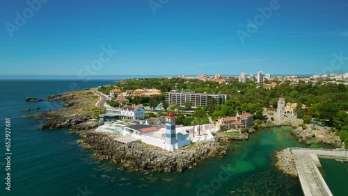 Aerial drone view of Santa Marta lighthouse with Cascais cityscape, Portugal. Orbit parallax shot