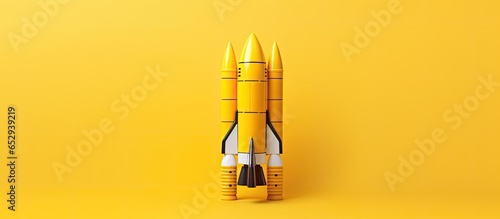 Minimalistic yellow toy spacecraft or rocket on a yellow backdrop representing a new and innovative concept in pop culture or business