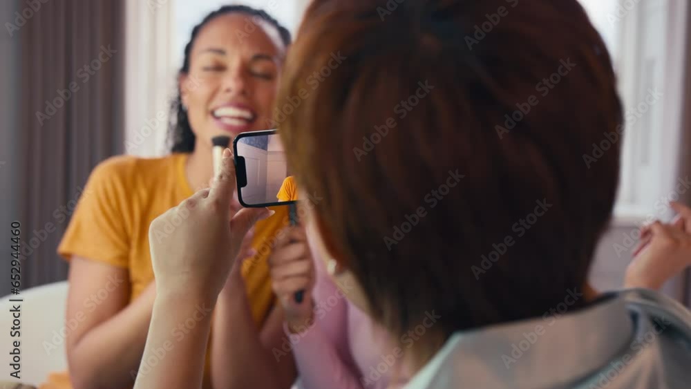 Female friends at home having fun recording video on phone miming singing song into make up brushes - shot in slow motion Female friends at home having fun recording video on phone miming singing song into make up brushes - shot in slow motion
