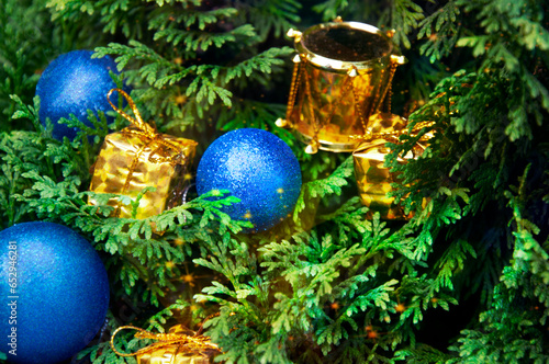 Christmas blue and yellow decoration close-up on spruce branches. Christmas and New Year holidays background.