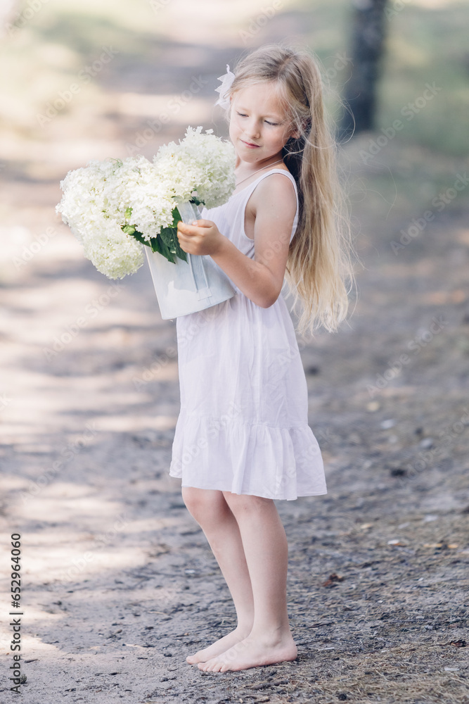 Portrait of a young beautiful girl holding a bouquet of white hydrangeas in her hands. Portrait of a young beautiful girl holding a bouquet of white hydrangeas in her hands.