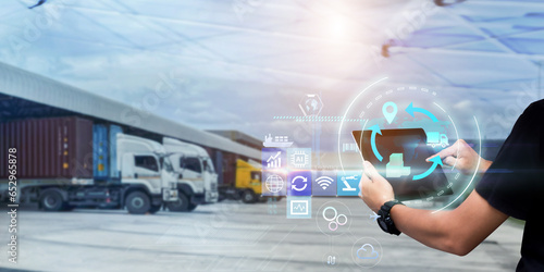 Business Logistics management technology concept.Man hands using tablet on blurred  Distribution Warehouse and Freight Truck