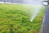 automatic lawn watering, automatic lawn watering system, automatic lawn watering water jet automatic lawn watering green lawn on a bright sunny day with a splash of water 