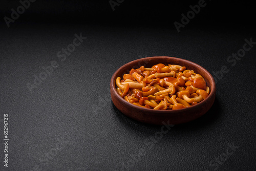 Delicious pickled honey mushrooms with salt and spices in a ceramic plate