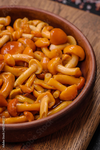 Delicious pickled honey mushrooms with salt and spices in a ceramic plate