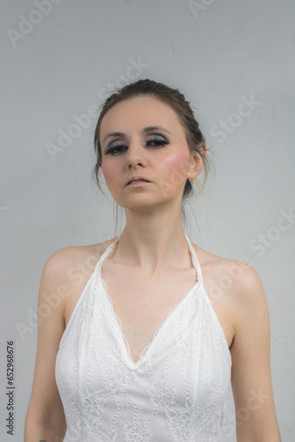 Beautiful young woman in a white lace dress. Studio shot.