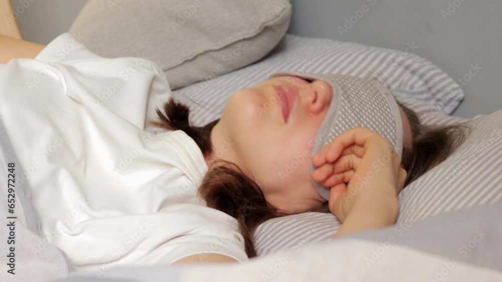 Restful Caucasian woman having sleep time lies on fresh linen, resting after hard day, being in resting state, fell into deep sleep wearing T-shirt and sleeping mask. Restful Caucasian woman having sleep time lies on fresh linen, resting after hard day, being in resting state, fell into deep sleep wearing T-shirt and sleeping mask.