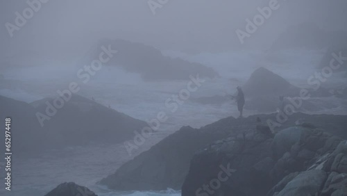 Silhouette of Man Fishing on Misty Coastline of Carmel By The Sea and Big Sur - a Rugged Stretch of California Central Coast known for Winding Roads and Seaside Cliffs