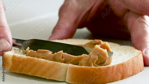 Close up of hands spreading jelly on a piece of bread