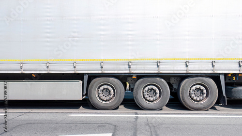 Generic simple commercial transport truck trailer side view detail, wheels closeup plain background with copy space Logistics company goods transportation business economy finance concept, backdrop