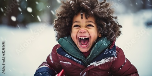 Black mixed race toddler child wearing a red coat laughing and having fun on a snow sled, skid, sledge, toboggan and sliding down hill of snow, winter snowy Christmas season | Generative AI