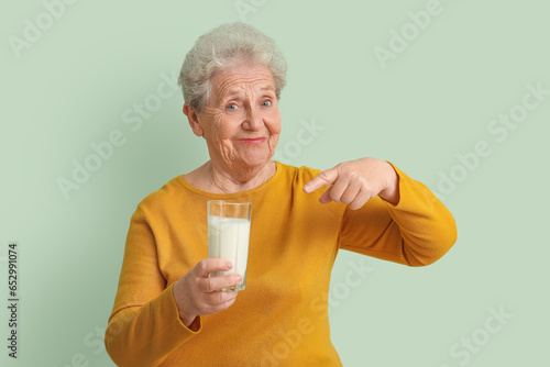 Senior woman pointing at gl...