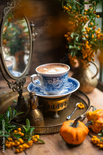 cup of cappuccino in still life. mirror behind the cup. beautiful picture. autumn still life.