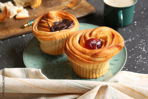 Plate of tasty cruffins with chocolate and jam on black background photo