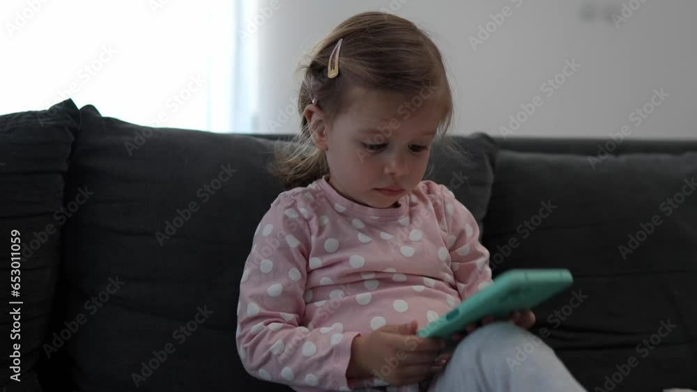 One girl toddler child play video game on mobile phone smartphone One girl toddler child play video game on mobile phone smartphone