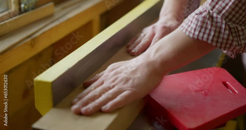 Close-up of the hands of a male carpenter or woodworker working an oak plank on a jointer planer in a carpentry or woodwork workshop. Processing of the tree. High quality 4k footage photo