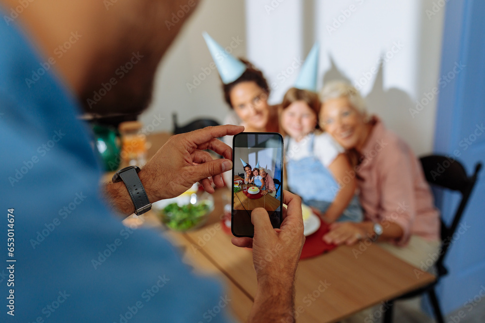 Father taking a photo of his family during grandmas birthday