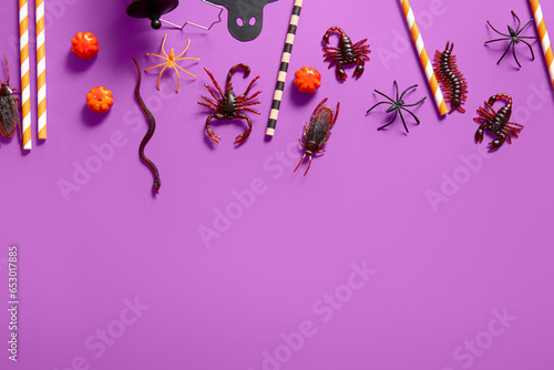 Halloween composition with candy bugs, pumpkins and straws on purple background © Pixel-Shot