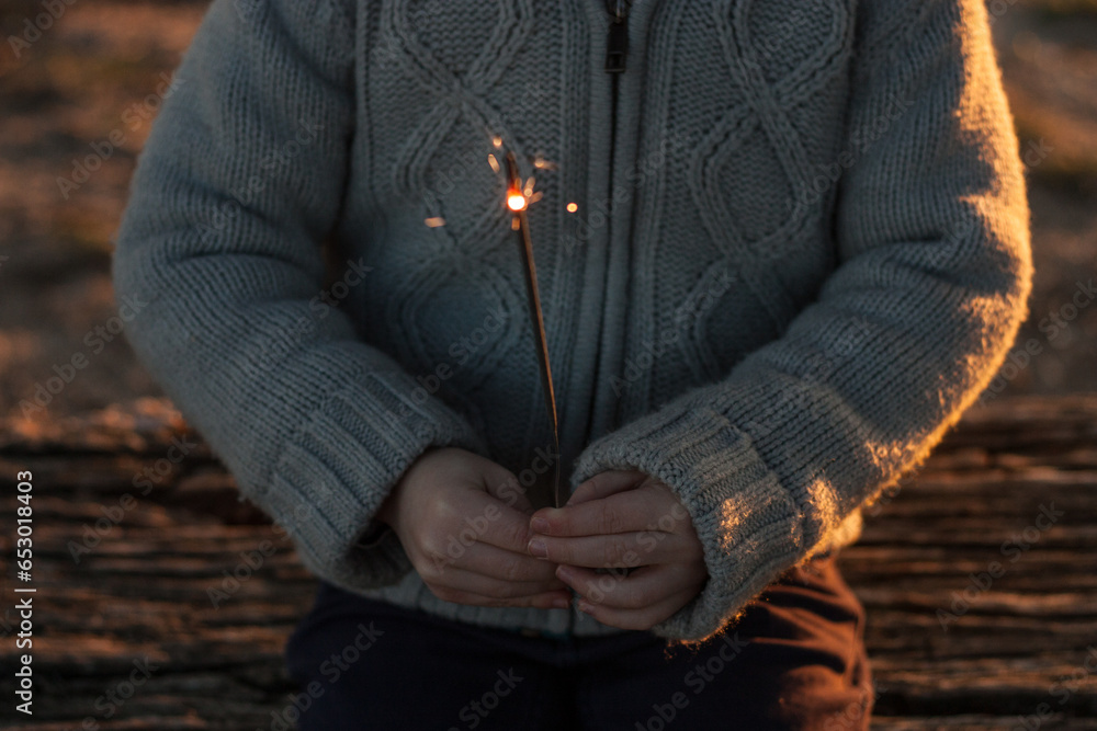 Sparkler in little boy's hands. Wish happy new year. Faceless. Horizontal. copy Space
