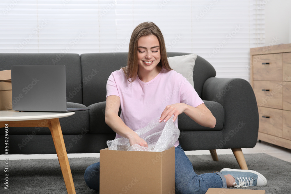 Happy woman unpacking parcel at home. Online store Happy woman unpacking parcel at home. Online store