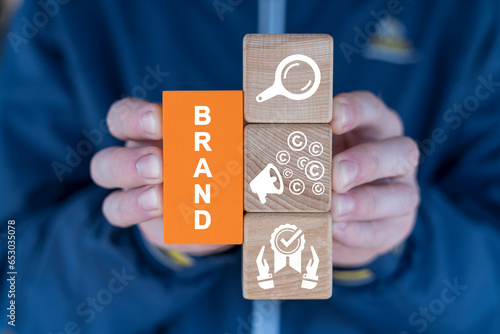 Hands holding colorful blcoks with icons and word: BRAND. Brand marketing and management, branding or rebranding concept. photo
