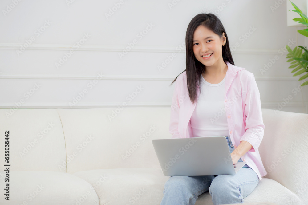 Young asian business woman work from home with laptop computer online to internet on sofa in living room, freelance girl using notebook sitting on couch with comfort and relax, lifestyles concept. Young asian business woman work from home with laptop computer online to internet on sofa in living room, freelance girl using notebook sitting on couch with comfort and relax, lifestyles concept.