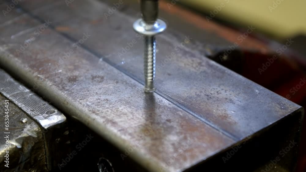 Tornillo autoperforante introduciéndose en un perfil metálico. Tornillo autoperforante introduciéndose en un perfil metálico.